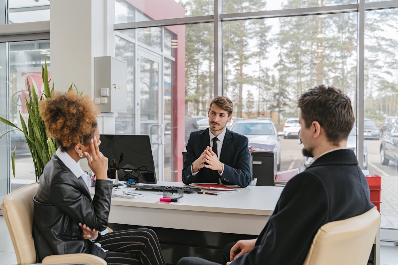 about-us Three adults in a modern office setting having a professional business meeting.